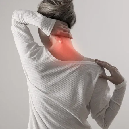 Person holding their neck and shoulder, indicating neck pain or discomfort.
